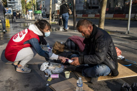 Bénévole aidant une personne dans la rue
