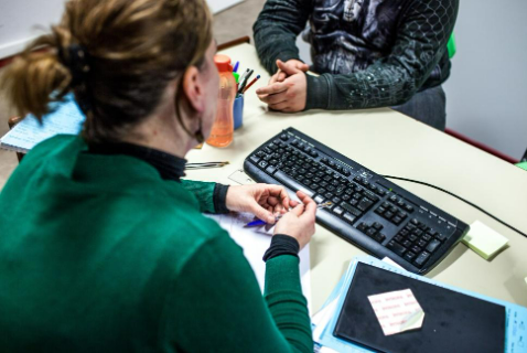 Personne aidant une autre à un bureau